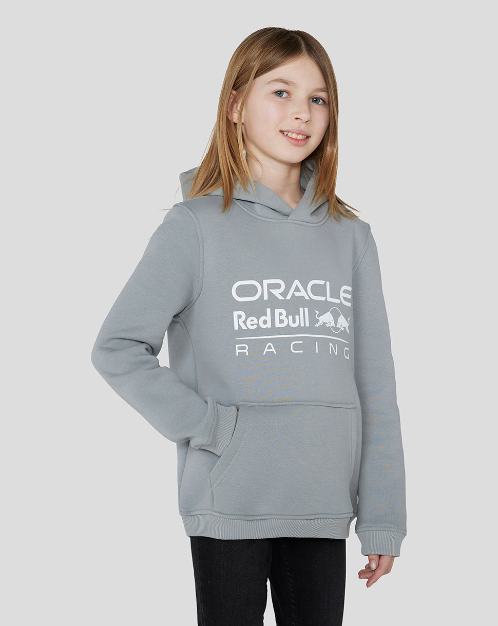 Front view of a girl in a grey Oracle Red Bull Racing Junior Core Overhead Hoodie with the brand logo on the chest.