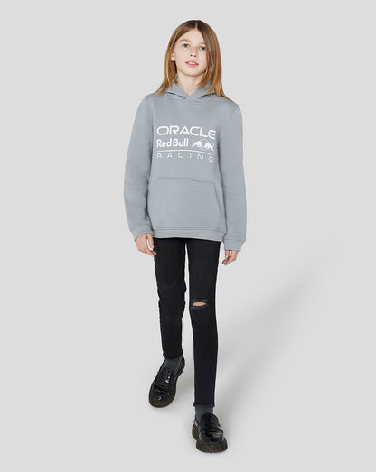Girl wearing a light grey Oracle Red Bull Racing Junior Core Overhead Hoodie with a white logo across the chest