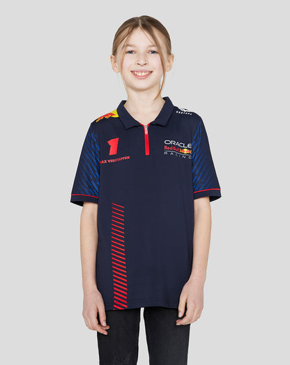 Front view of a smiling girl wearing a navy Oracle Red Bull Racing junior polo with Verstappen branding