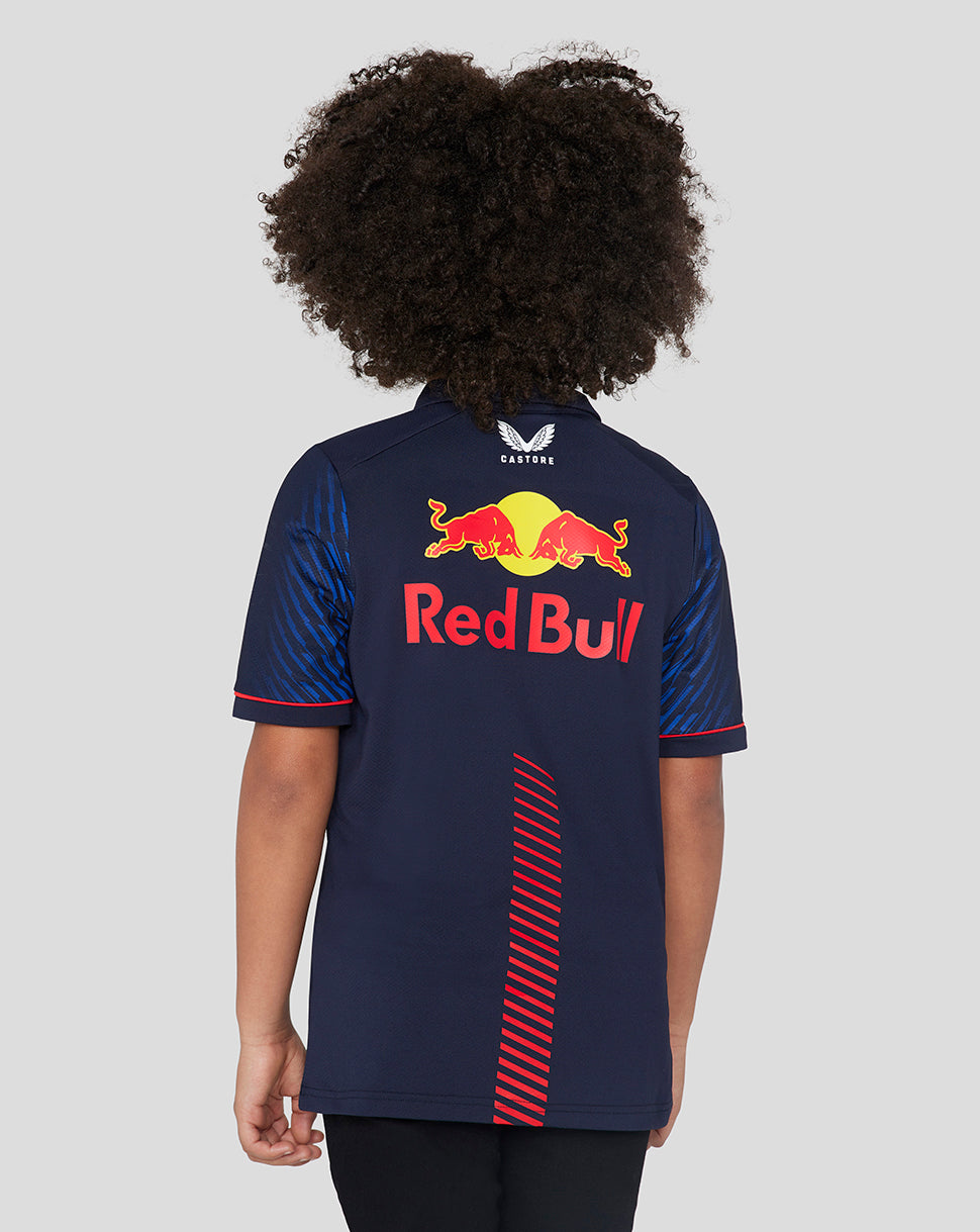 Back view of a girl in a navy Red Bull Racing polo showing the large Red Bull logo on the back