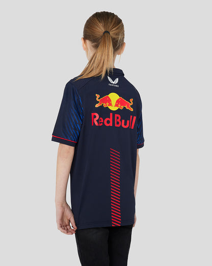 Back view of a young model wearing a night sky navy Red Bull Racing polo with a large logo on the back.