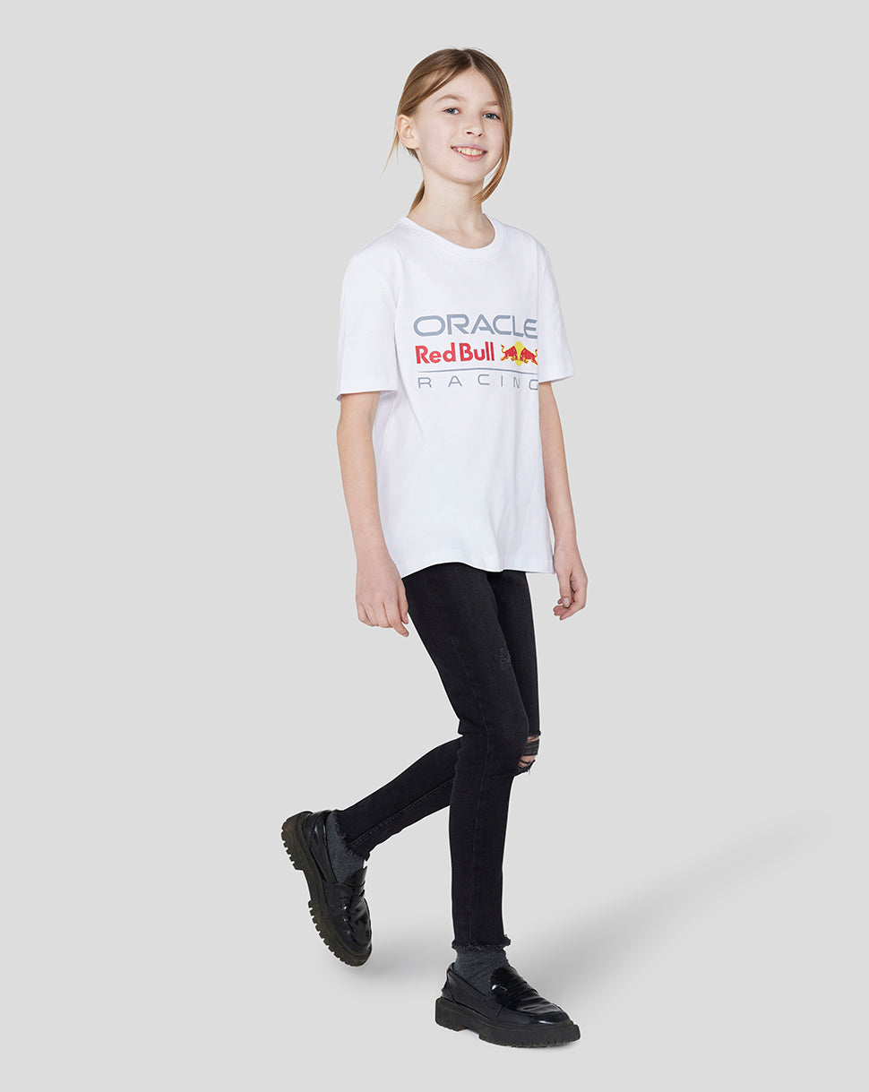 Girl in white Oracle Red Bull Racing Junior Large Front Logo T shirt with the colorful logo on the chest