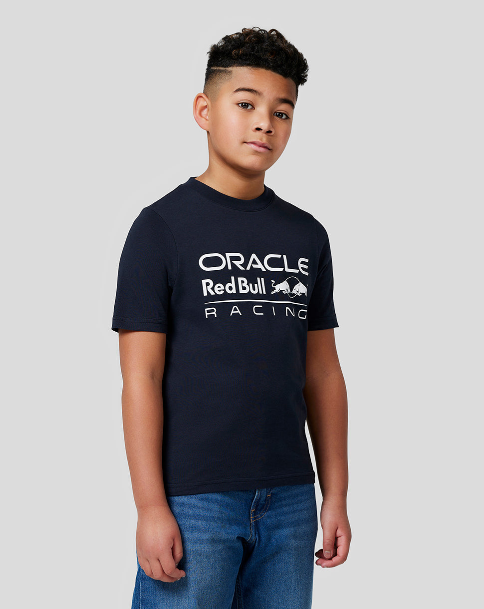 Young boy in a navy Oracle Red Bull Racing t shirt with a large white front logo.