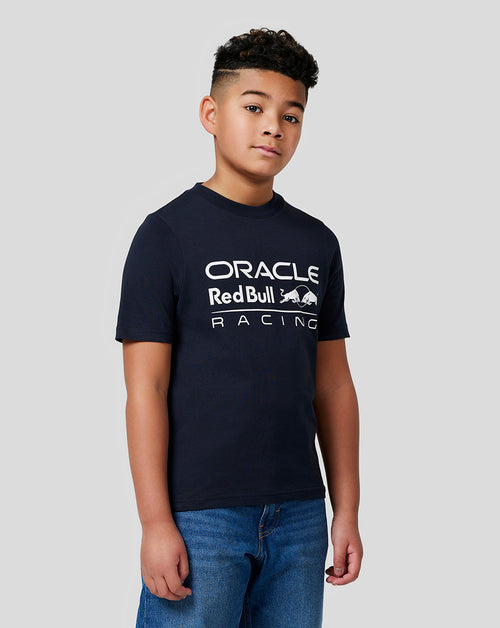 Young boy in a navy Oracle Red Bull Racing t shirt with a large white front logo.