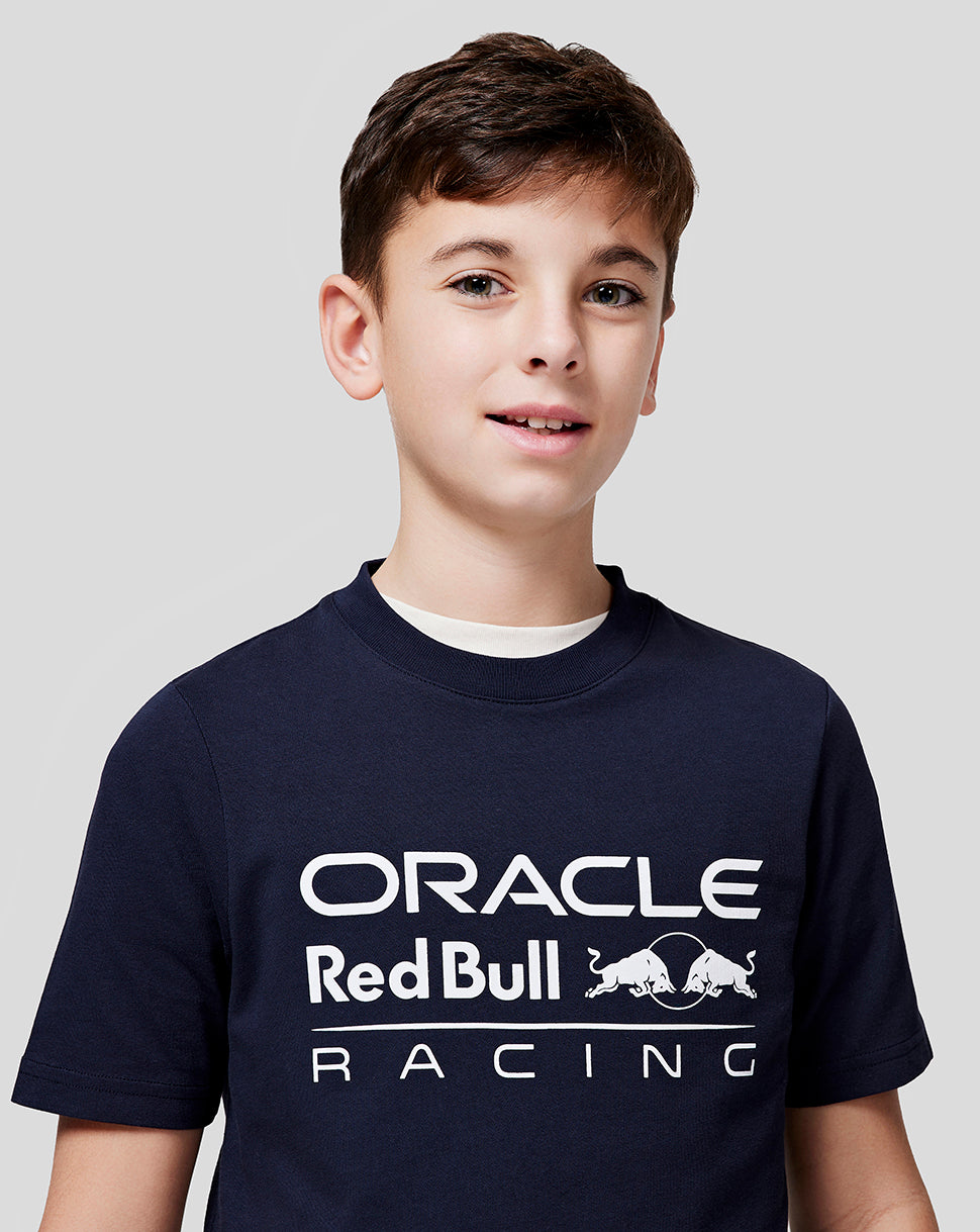 Close-up of a boy wearing a navy Oracle Red Bull Racing T shirt with the large white front logo.