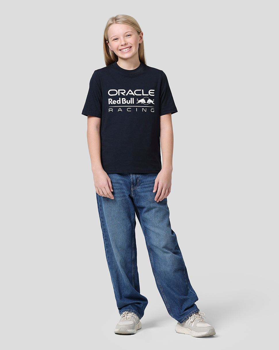 Smiling boy wearing a navy Night Sky Oracle Red Bull Racing Junior Large Front Logo T Shirt with the large front logo