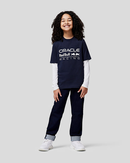 Smiling girl wearing a navy Night Sky Oracle Red Bull Racing Junior Large Front Logo T Shirt with the large front logo