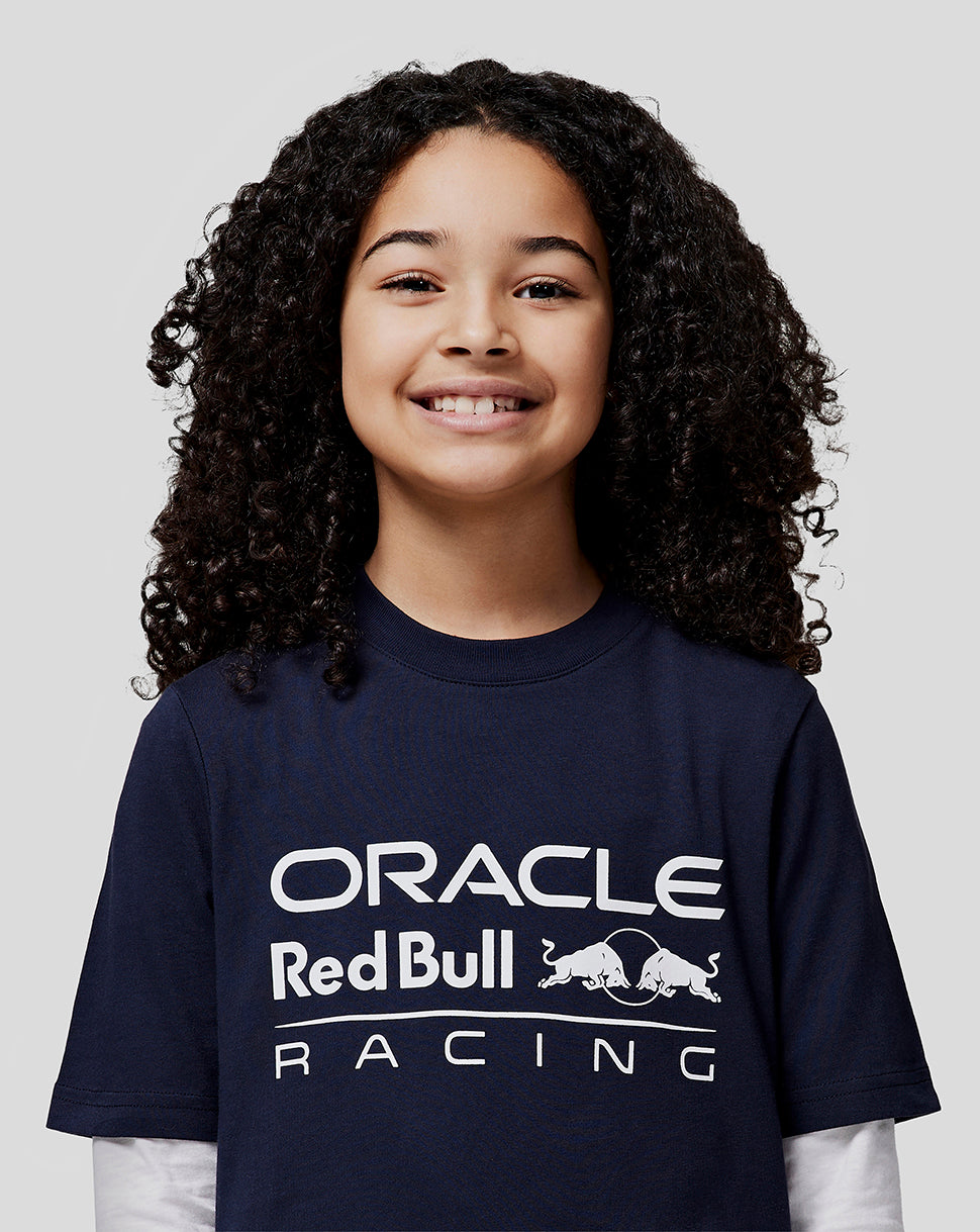 Smiling girl in a navy Oracle Red Bull Racing t shirt with a large white front logo.