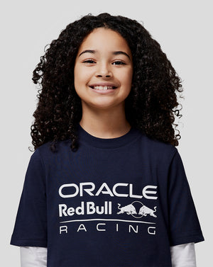 Smiling girl in a navy Oracle Red Bull Racing t shirt with a large white front logo.
