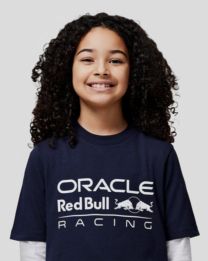 Smiling girl in a navy Oracle Red Bull Racing t shirt with a large white front logo.