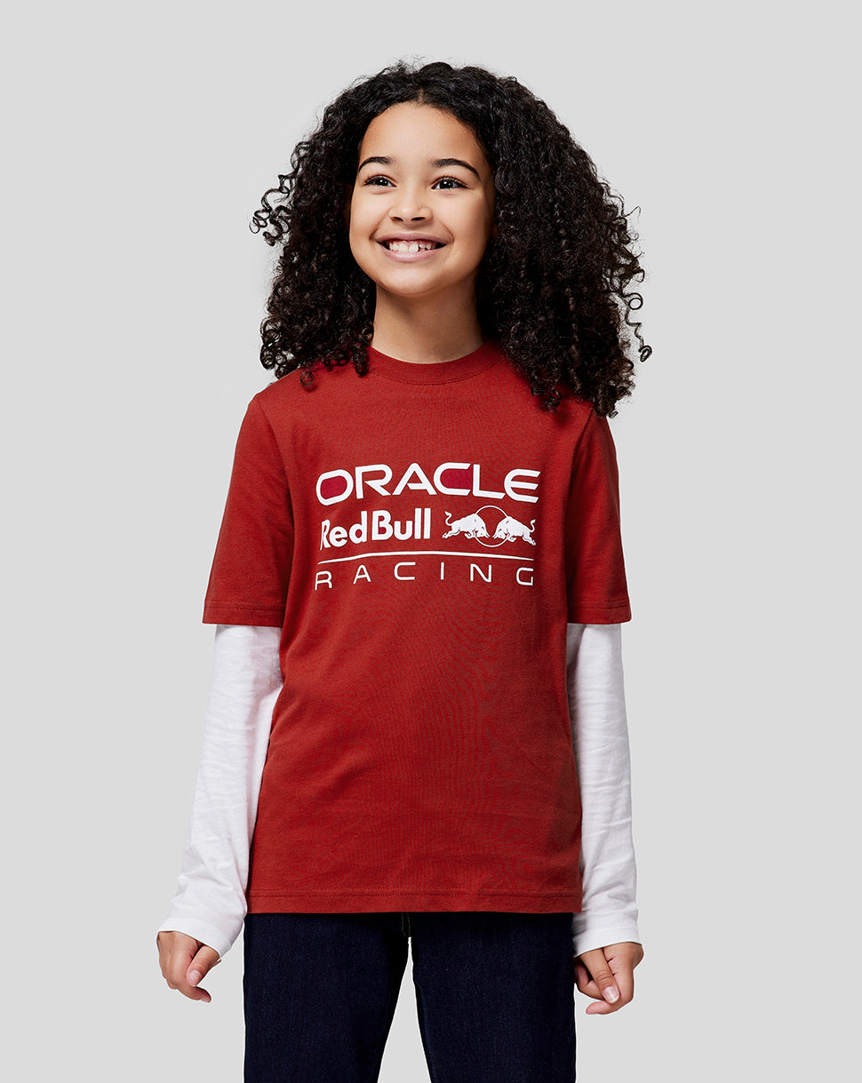 Smiling girl in a red Oracle Red Bull Racing T shirt from the juniors collection.