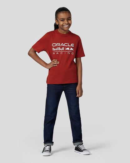 Smiling girl wearing a red Oracle Red Bull Racing T shirt with the logo on the front.