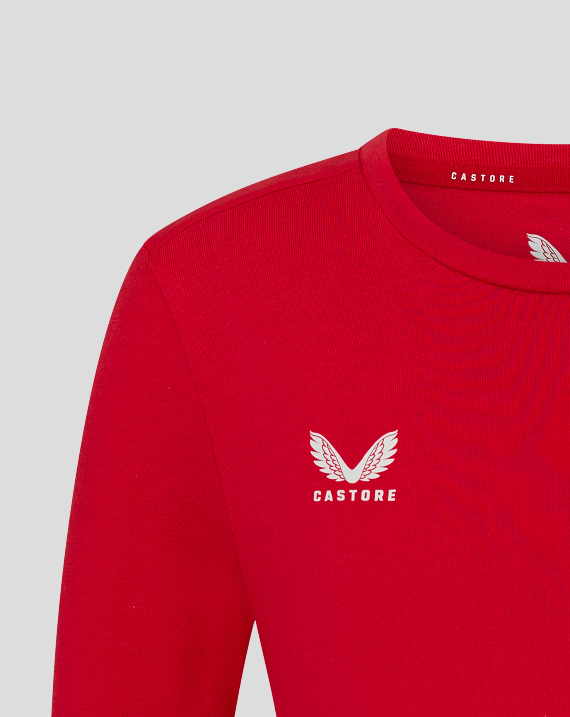 Front close-up of red tee showing a large white wing logo with Castore text.