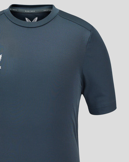 Close-up of dark slate Junior Performance Tee showing crew neck collar, set-in sleeve seam, and Castore branding near the neckline.