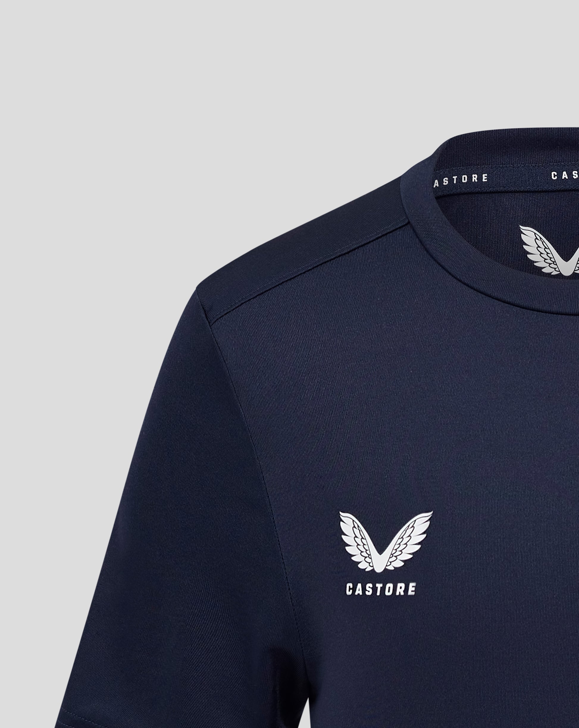 Close up of navy Junior Performance Tee collar and shoulder seam with Castore logo