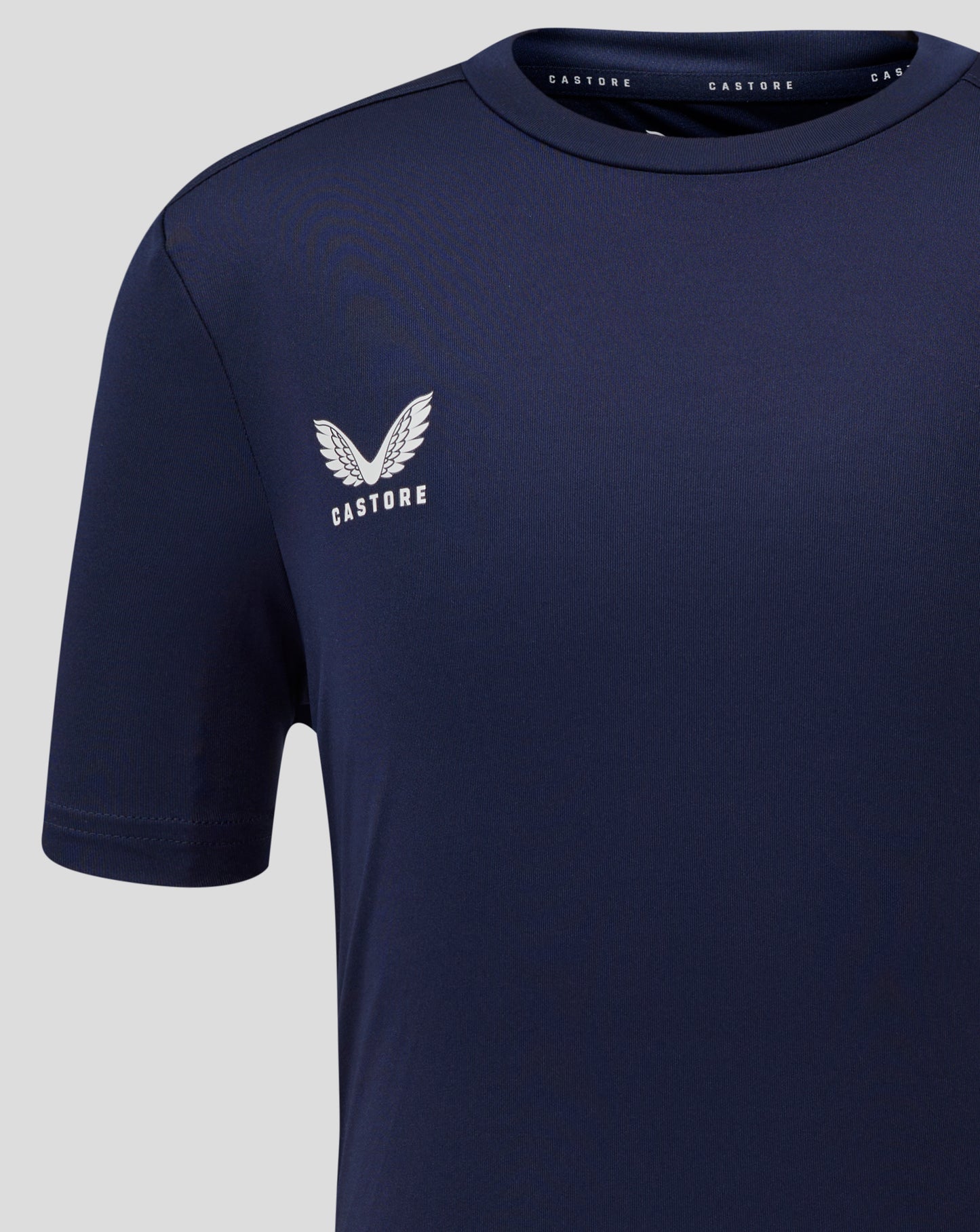 Close up of left chest with Castore logo on navy Junior Performance Tee.