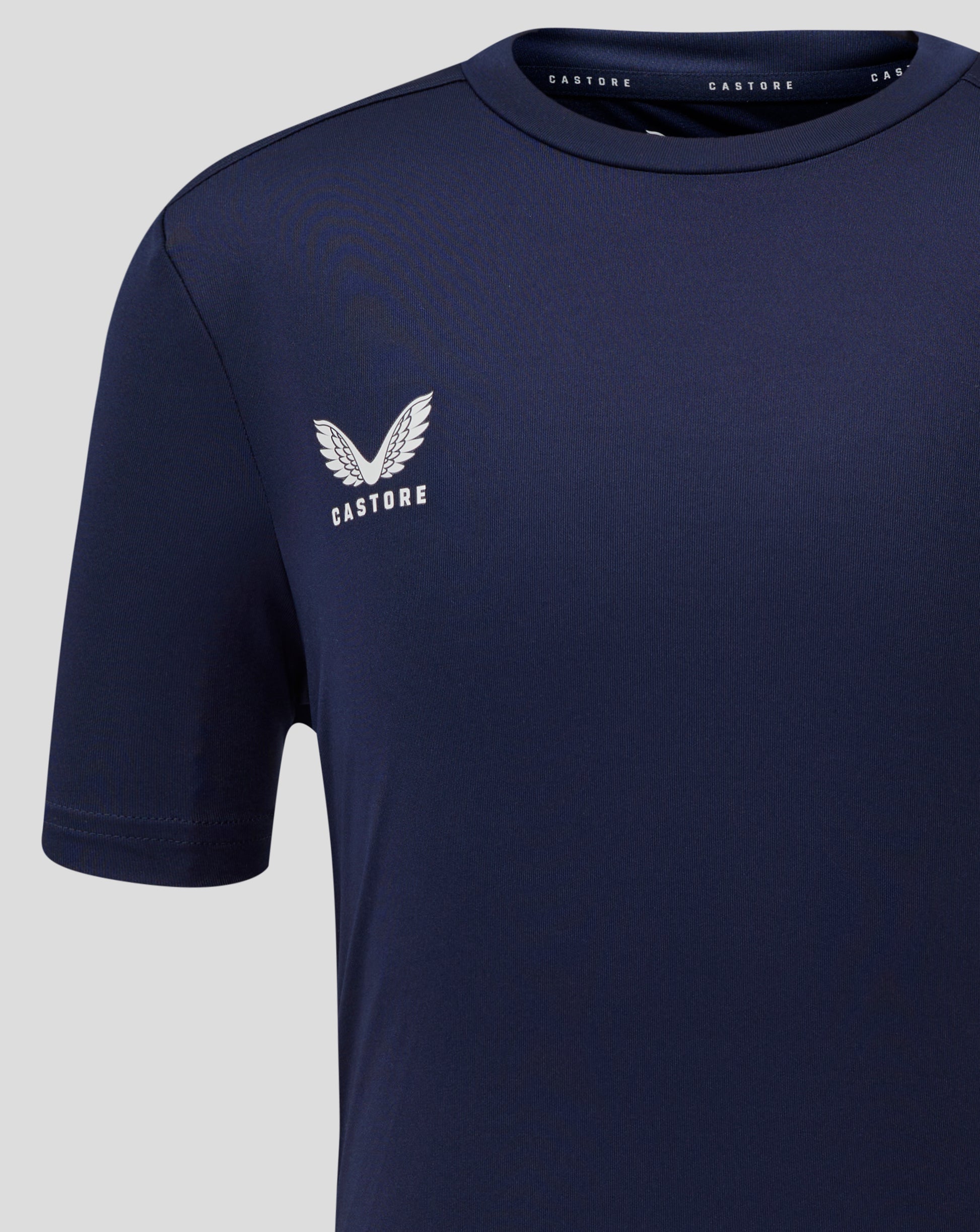 Close up of left chest with Castore logo on navy Junior Performance Tee.