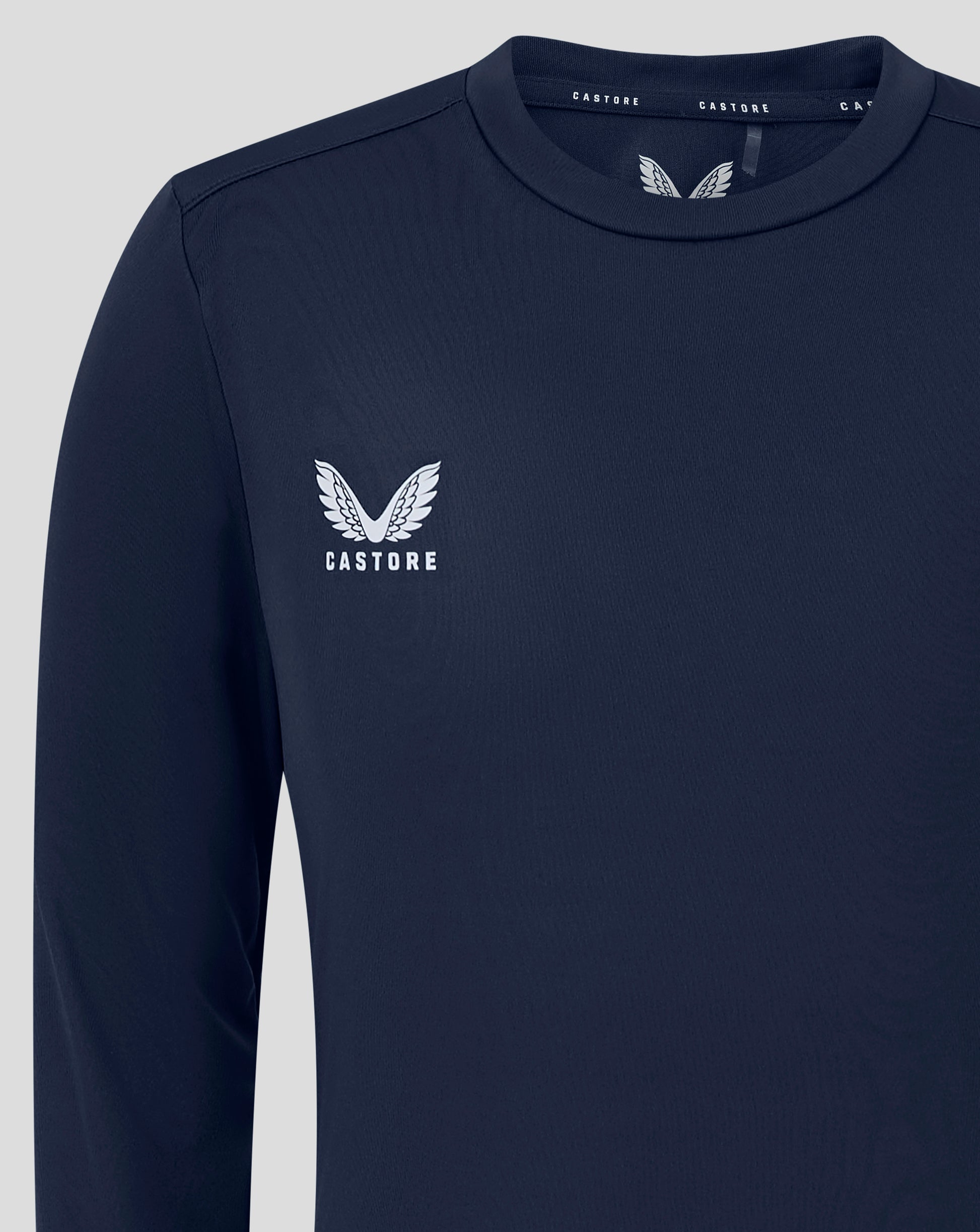 Navy junior long sleeve performance tee with crew neck and white Castore logo on the chest