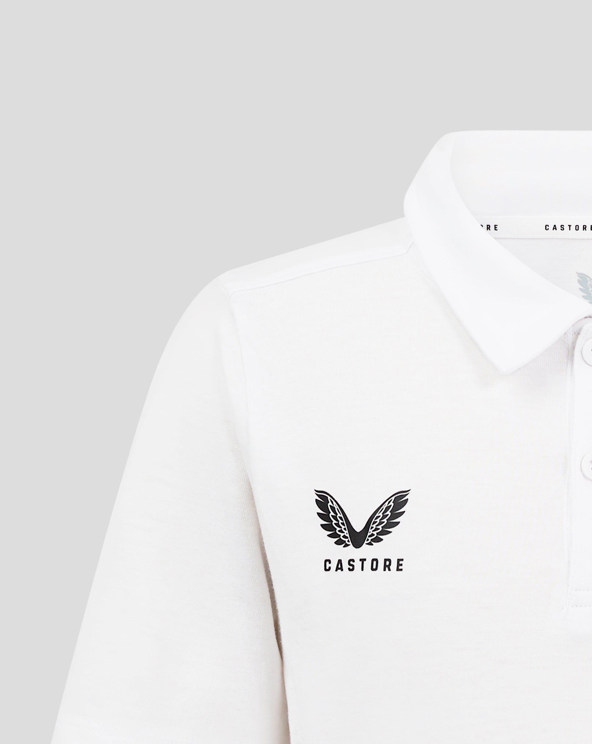 Close-up of the white polo showing the large Castore wing logo on the chest