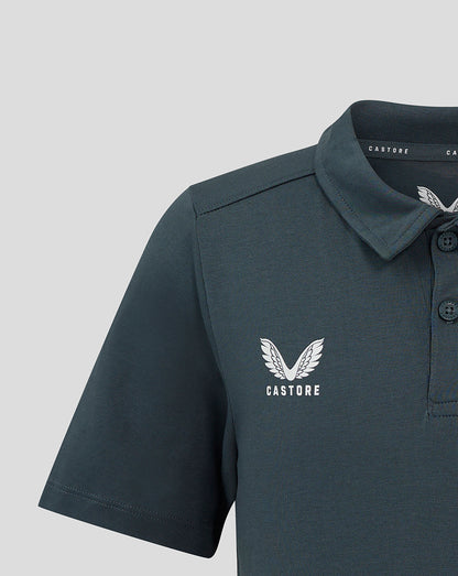 Close-up of the dark slate junior polo showing the white crest on the left chest and collar details