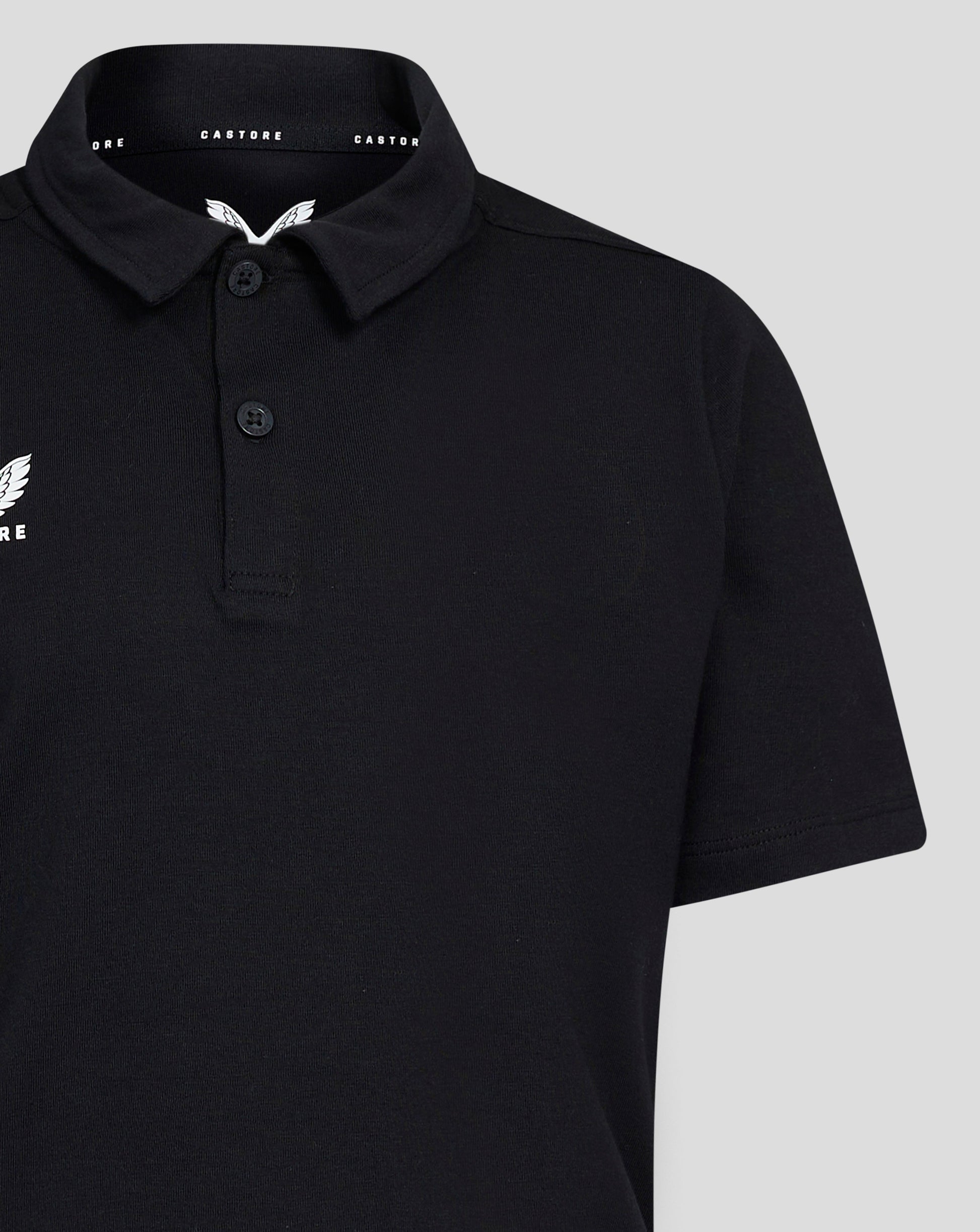 Close up of collar and left chest Castore wing logo on black Junior Cotton Leisure Polo