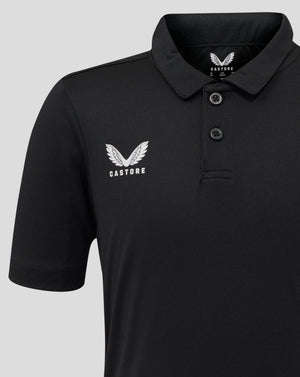Close-up of black Junior Performance Polo with white Castore wing logo on the left chest and visible collar edge