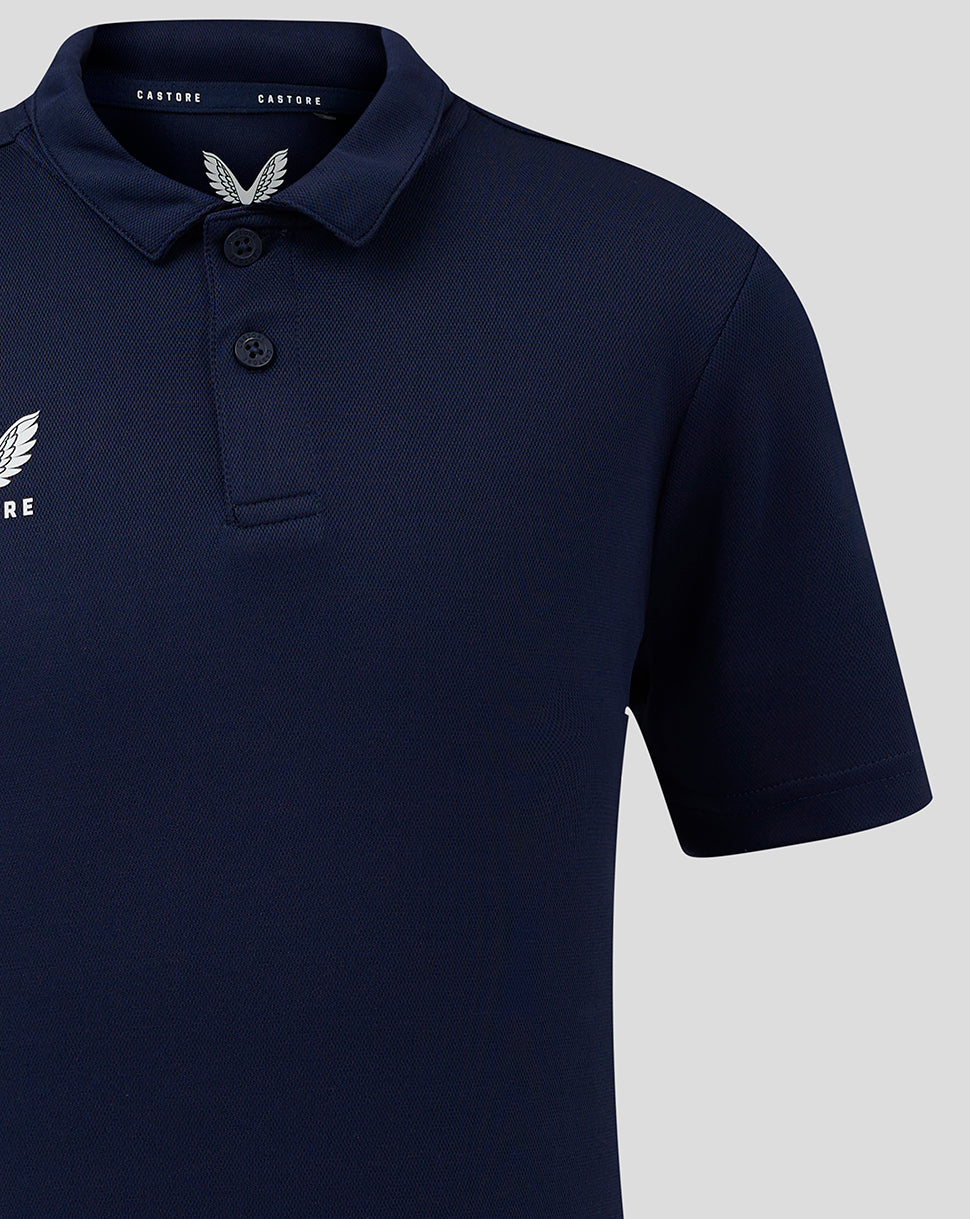 Close up of Junior Performance Polo in peacoat navy showing collar and Castore wing logo on chest