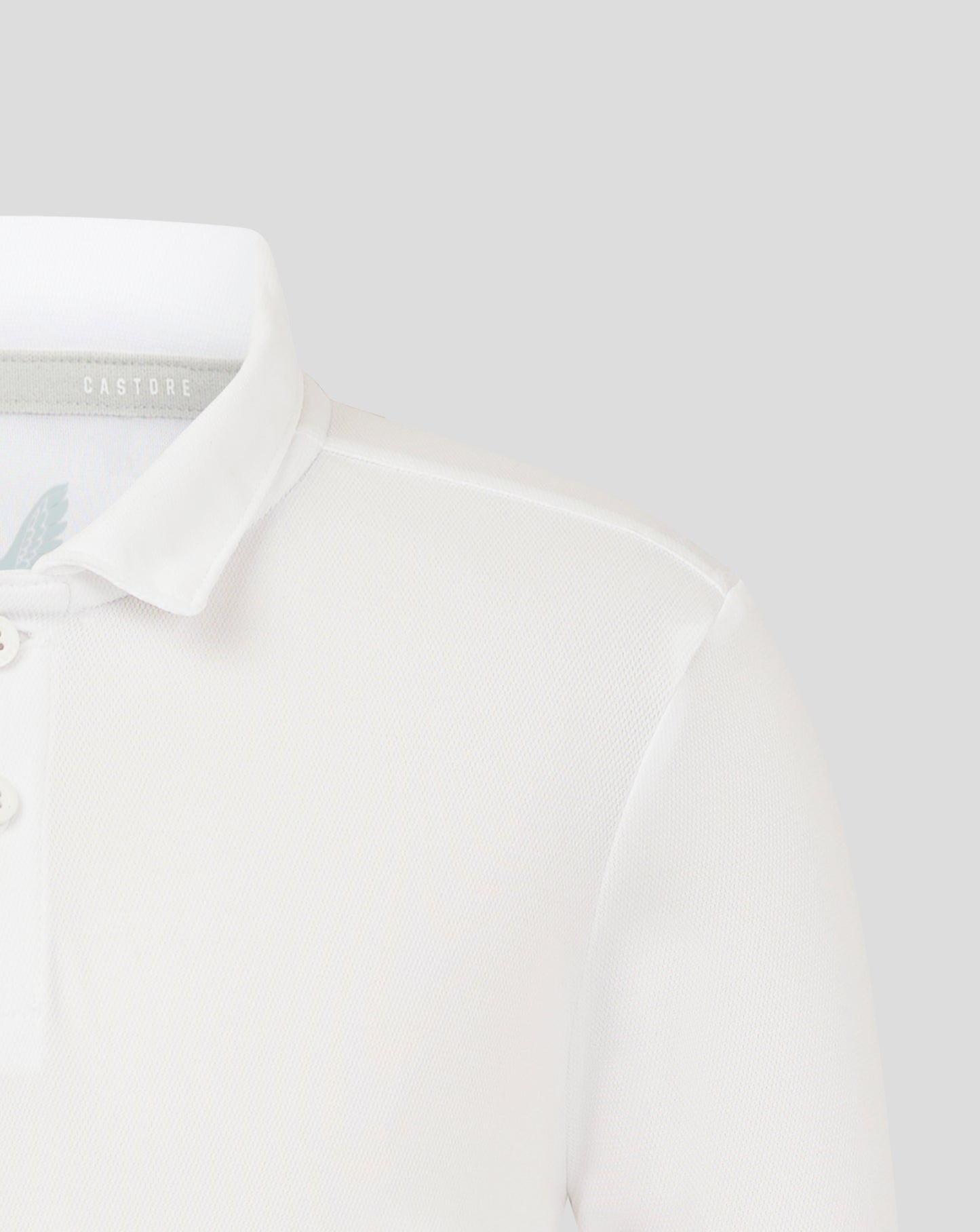 Close up of white junior polo collar with Castore label inside and partial wing logo on chest