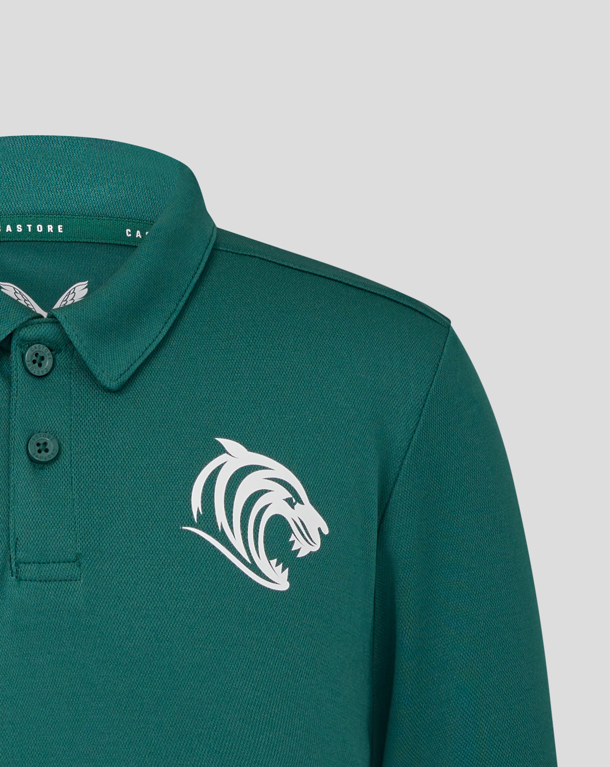 Front view of teal training polo with Castore logo on chest and partial wing emblem visible
