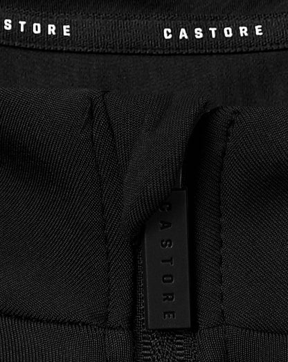 Close-up of black fabric with a vertical zipper and a Castore branded strap detail from a junior quarter zip top