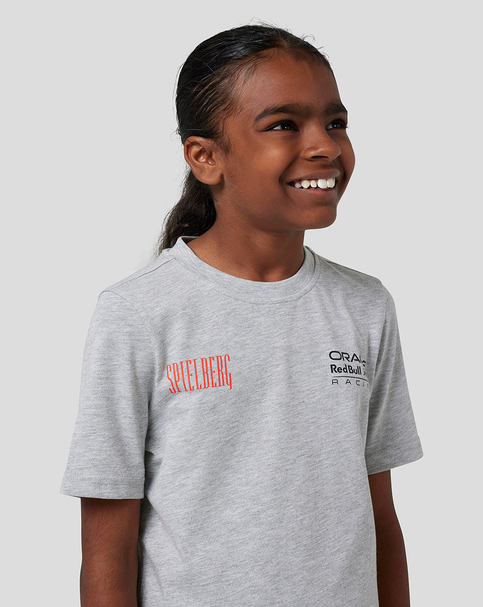 Child wearing grey marl Red Bull Racing Spielberg T shirt with Spielberg logo on the chest and Oracle Red Bull Racing logo on the front