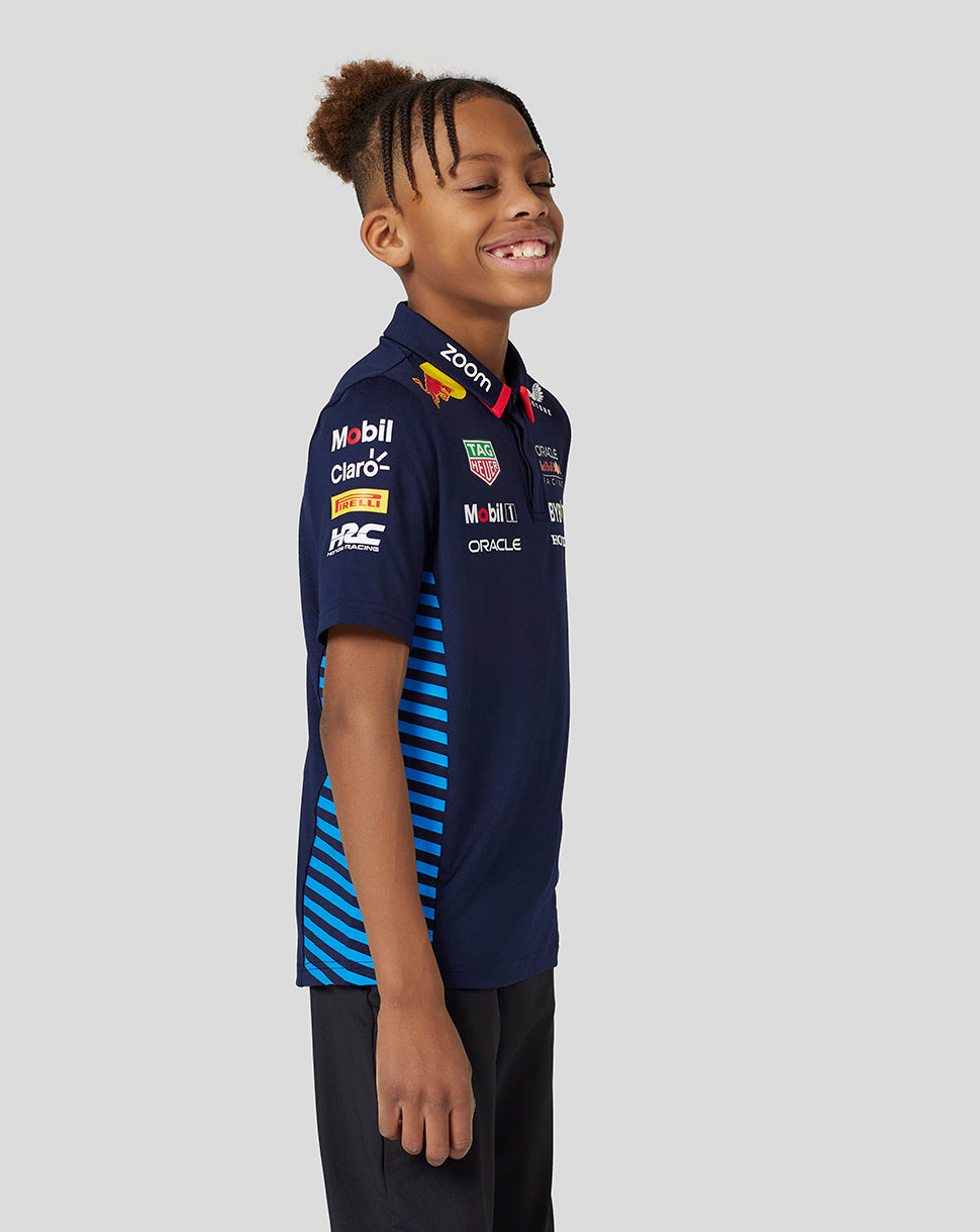 Junior wearing navy Night Sky Oracle Red Bull Racing Teamline short sleeve polo with jacquard knit and side mesh panels.