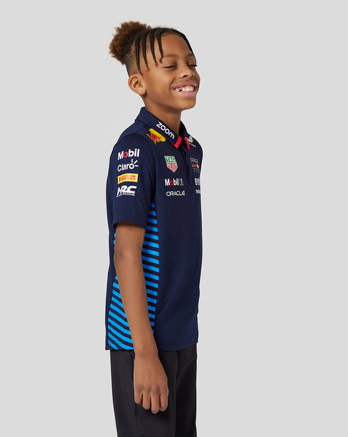 Junior wearing navy Night Sky Oracle Red Bull Racing Teamline short sleeve polo with jacquard knit and side mesh panels.