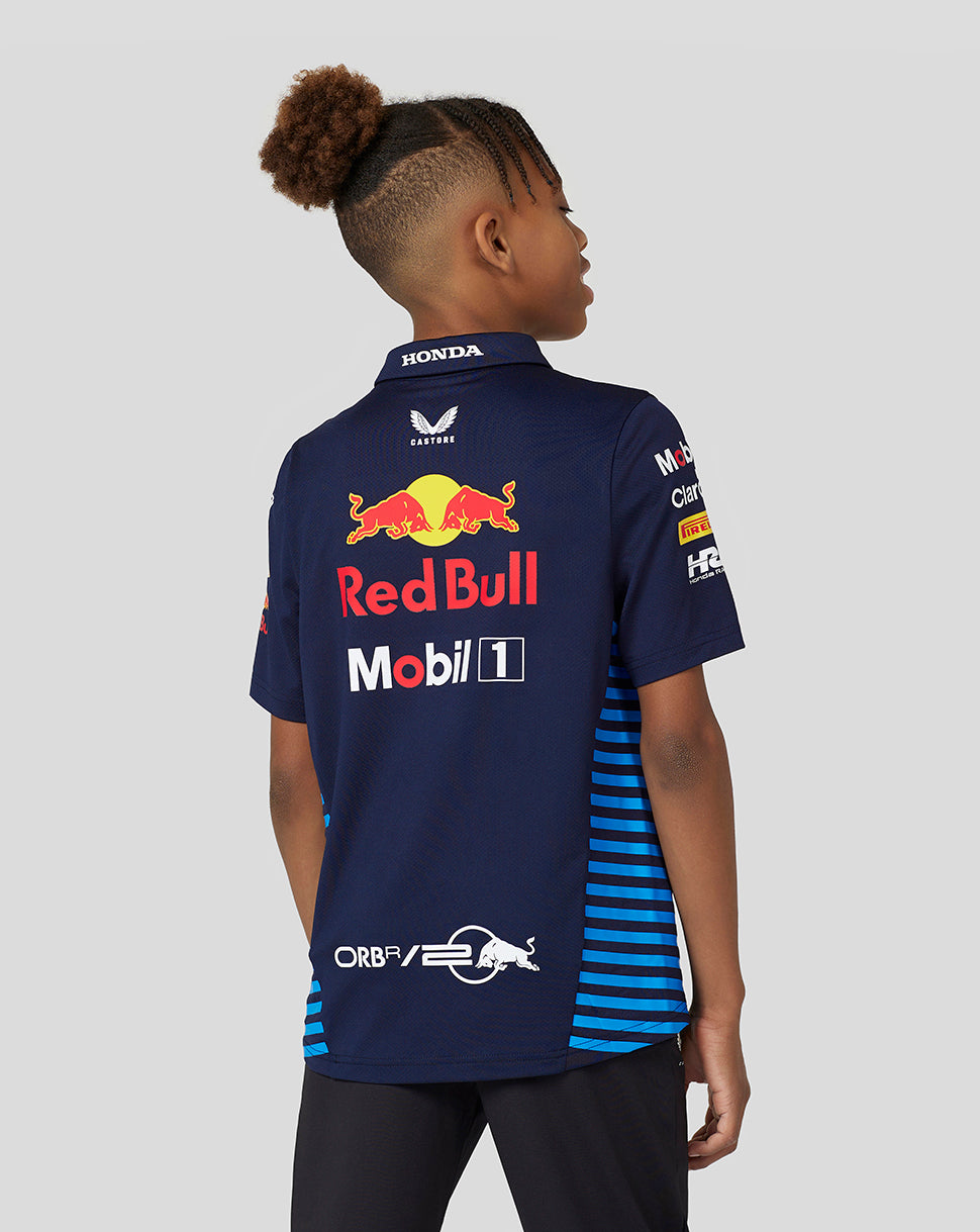 Back view of a young girl in a navy Red Bull Racing junior polo featuring large Red Bull branding on the back