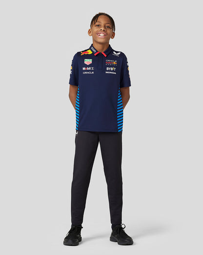 Front view of a smiling child in a navy Teamline polo with sponsor logos and blue striped side panels