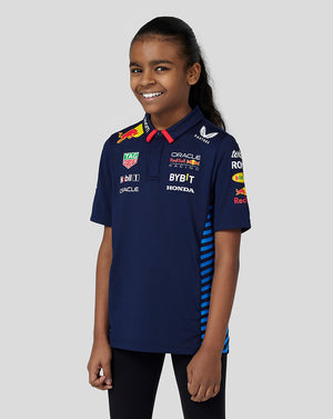 Young girl wearing navy Night Sky Oracle Red Bull Racing junior polo with team sponsor logos on the chest