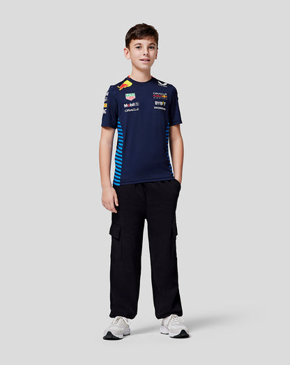 Boy in navy Oracle Red Bull Racing Set Up Tee with blue side stripes black cargo pants and white sneakers