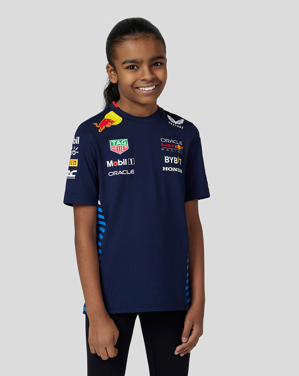 Front view of a smiling girl in a navy Red Bull Racing Teamline Set Up Tee with multiple sponsor logos on the chest