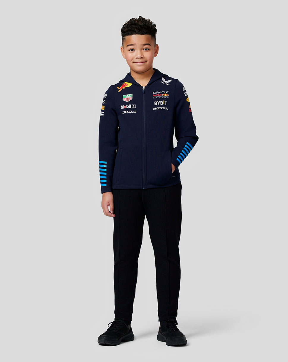 Young model wearing navy Night Sky Oracle Red Bull Racing Teamline full zip hoodie with sponsor logos and blue striped sleeves.