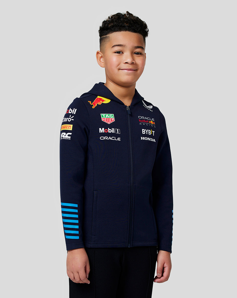 Junior boy in navy Night Sky Oracle Red Bull Racing Teamline full zip hoodie showing chest logos and blue striped sleeves.