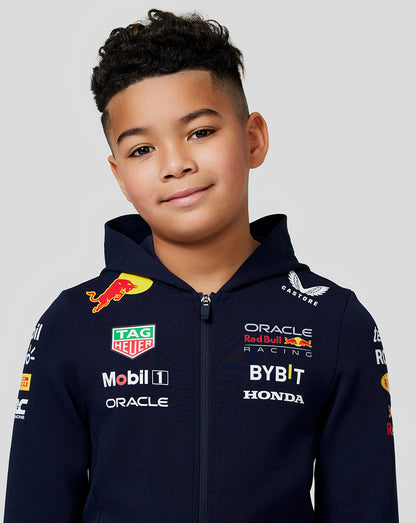 Front view of a smiling boy in a navy Oracle Red Bull Racing junior hoodie with sponsor logos on the chest and sleeves.