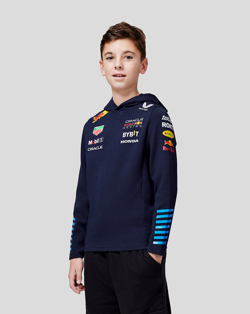 Child in a navy Night Sky Teamline pullover hoodie with back graphic and branding on the chest and sleeves