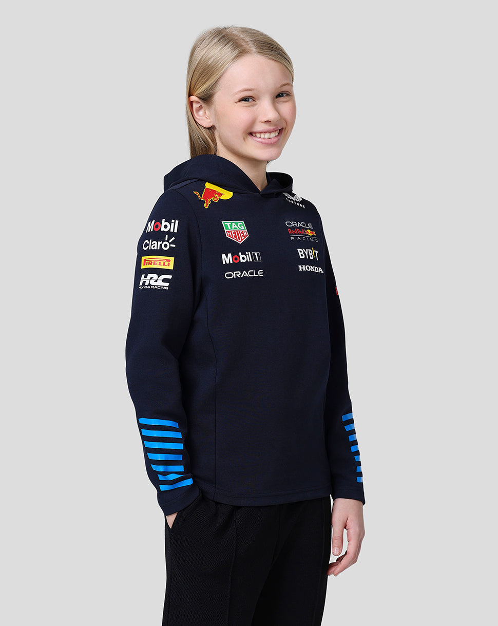 Young girl wearing a navy Oracle Red Bull Racing hoodie with sponsor logos on chest and sleeves and a large back graphic.