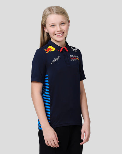 Young girl wearing a navy Oracle Red Bull Racing Junior Teamline polo with blue side stripes