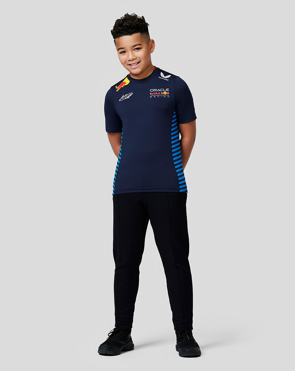 Smiling boy modeling the Night Sky Oracle Red Bull Racing Junior Teamline Max Verstappen T shirt with blue side stripes