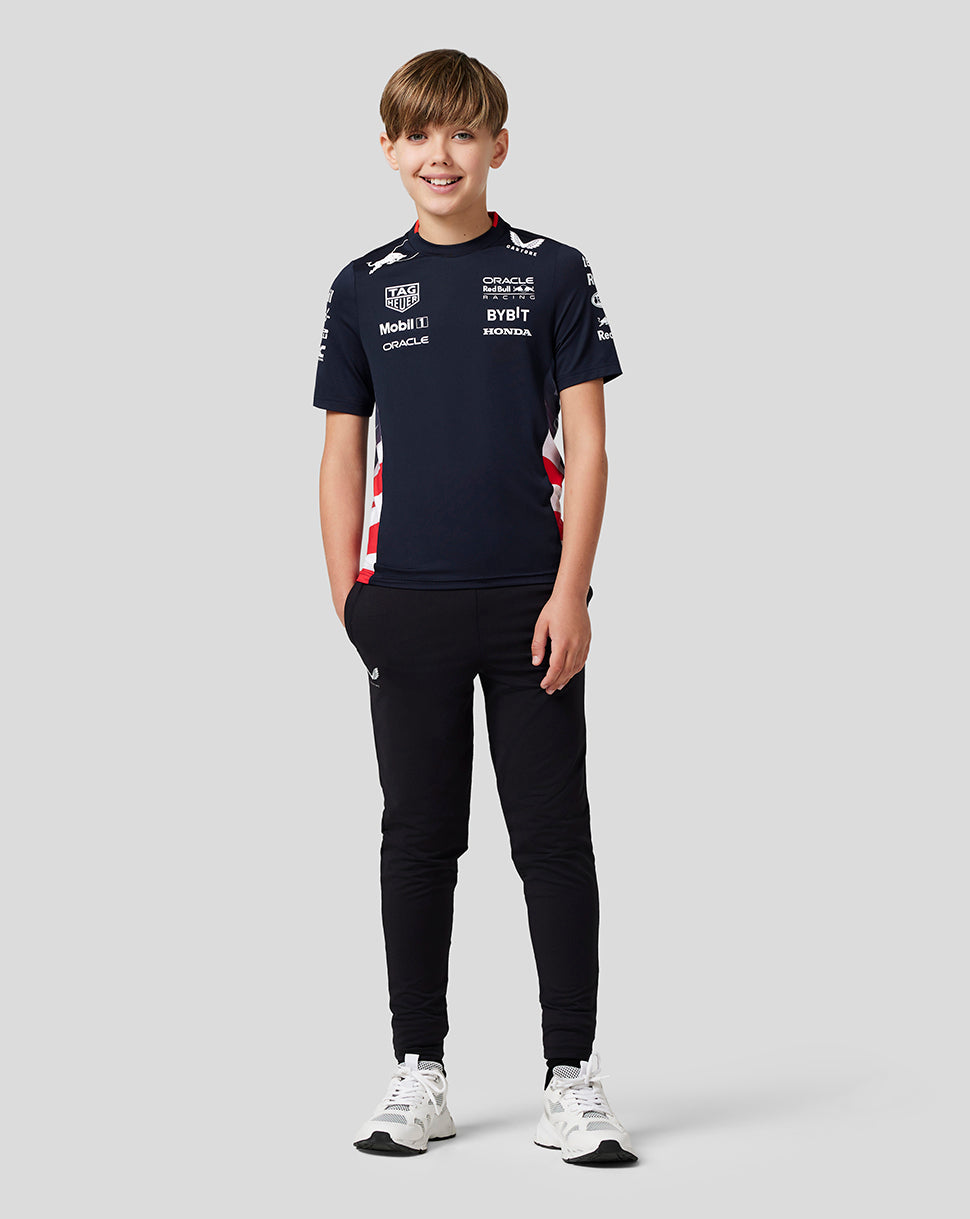 Rear view of a boy in navy Night Sky Teamline shirt with Red Bull branding and sponsor logos