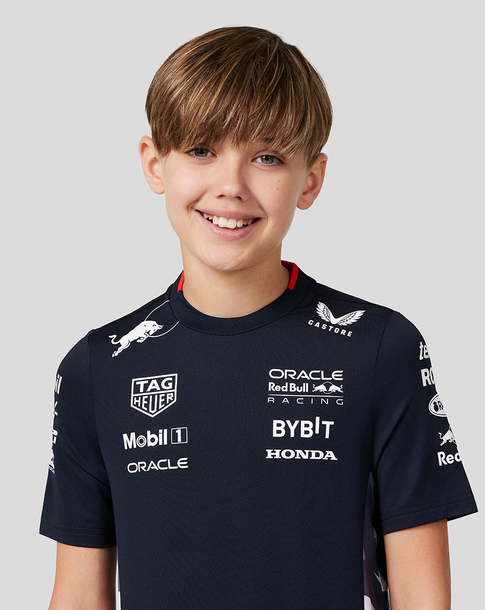 Smiling boy wearing navy Night Sky Oracle Red Bull Racing Junior Teamline America T Shirt front view with sponsor logos