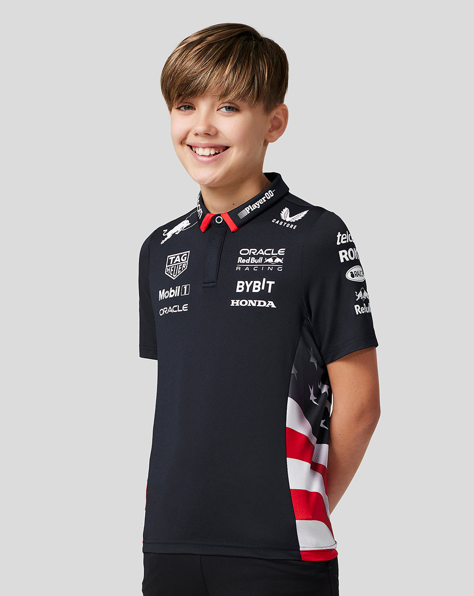 Smiling boy in a navy junior America Race Team polo with sponsor logos on the chest.
