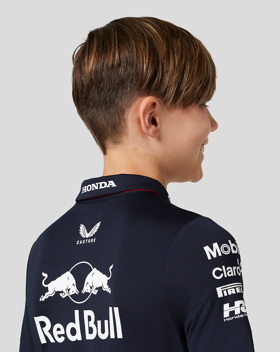 Back view of a boy in a Night Sky navy polo with large Red Bull Racing back logo and sponsors.