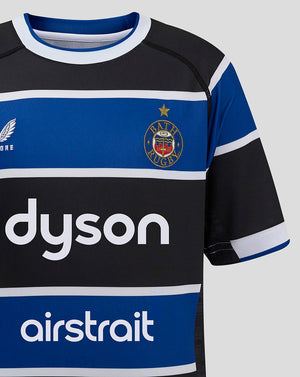 Close up front of Bath Rugby Junior Home Shirt showing the Bath crest on the left chest and Dyson sponsor across the blue stripe.